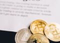 Police officers examining Bitcoin coins and financial documents related to crypto seizure.