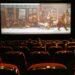 A movie theater with a screen displaying an AI short film announcement.
