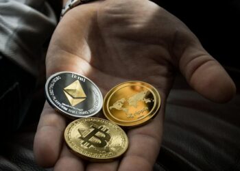 Two hands exchanging digital coins with a backdrop of blockchain graphics and financial symbols.