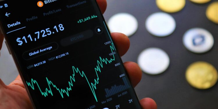 A distressed person staring at a cryptocurrency trading app on a smartphone.