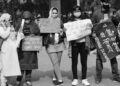 Crowd of protesters holding signs outside OpenAI offices, demanding a halt to AI development.