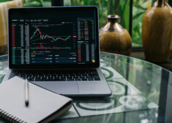 A trader examines digital stock charts on a laptop, symbolizing the rise of tokenized trading.