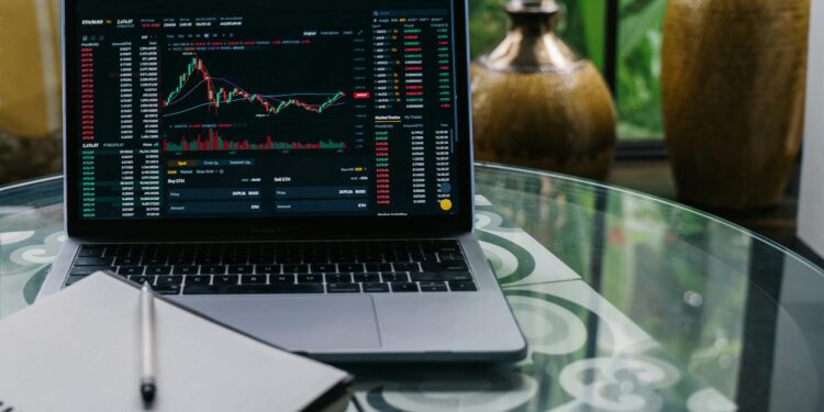 A trader examines digital stock charts on a laptop, symbolizing the rise of tokenized trading.