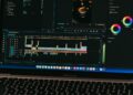 A laptop displays Sora's text-to-video interface with digital graphics in the background.