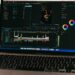 A laptop displays Sora's text-to-video interface with digital graphics in the background.