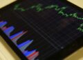 HYPE Tokens displayed on a digital screen with graphs showing crypto market fluctuations.