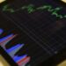 HYPE Tokens displayed on a digital screen with graphs showing crypto market fluctuations.