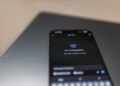 A group of diverse users discussing privacy concerns over a smartphone displaying an AI assistant.