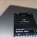 A group of diverse users discussing privacy concerns over a smartphone displaying an AI assistant.