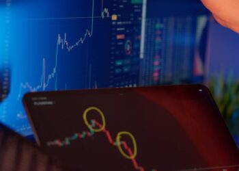 Graph showing Bitcoin and Ethereum price trends with a financial analyst in the background.