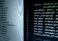 Developers monitoring code with warning signs for malicious Axios packages in a foggy environment.