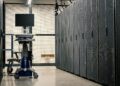 Workers setting up AI servers at a Bitfarms facility in the U.S. amidst crypto equipment.
