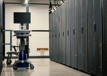Workers setting up AI servers at a Bitfarms facility in the U.S. amidst crypto equipment.