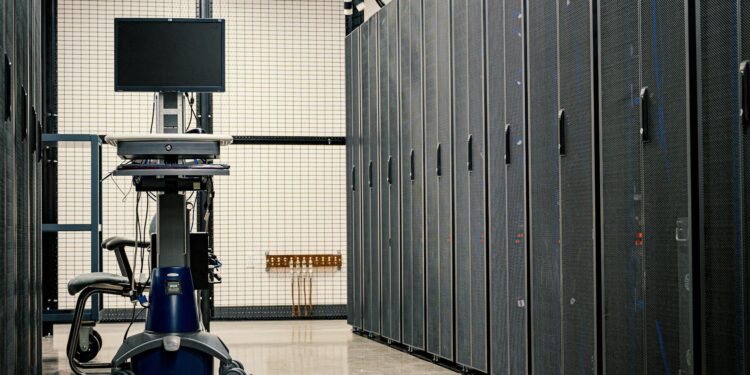 Workers setting up AI servers at a Bitfarms facility in the U.S. amidst crypto equipment.