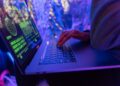 A hacker's hand on a keyboard, symbolizing cyber threats in cryptocurrency phishing attacks.