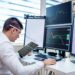 Traders monitoring oil futures on electronic screens in a busy financial trading environment.