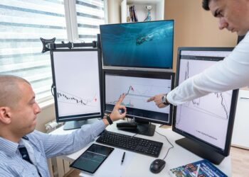 Traders analyzing cryptocurrency graphs and data on multiple screens.