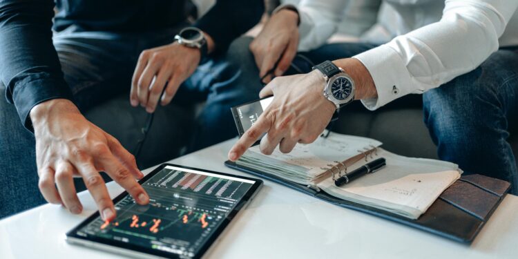 Congress members discuss financial regulations with a digital trading platform in the background.