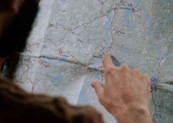 Trump and Iranian officials discussing maritime security over a map of the Strait of Hormuz.