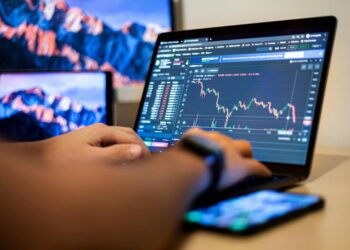 A person using a smartphone to access a cryptocurrency trading platform.