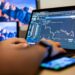 A person using a smartphone to access a cryptocurrency trading platform.
