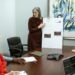 Michael Saylor speaking at a conference with Bitcoin graphics and financial charts in background.