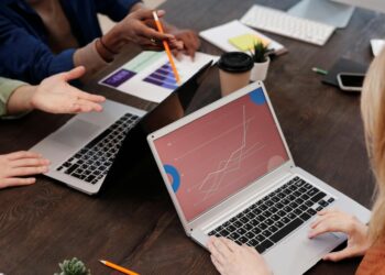 A modern office setting with team members discussing blockchain technology over laptops.