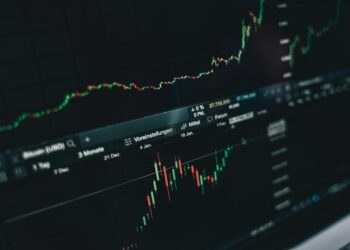 Traders monitoring cryptocurrency prices on screens, highlighting XRP and Solana declines.