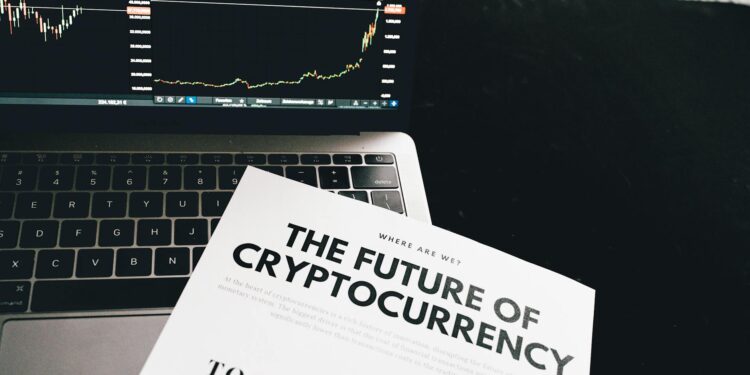 A person analyzing cryptocurrency charts on a laptop, surrounded by financial documents.