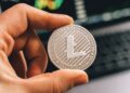 A close-up of a digital currency symbol overlaying a blurred financial market background.
