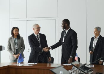 Ripple representatives shake hands with Singapore Central Bank officials in a conference setting.