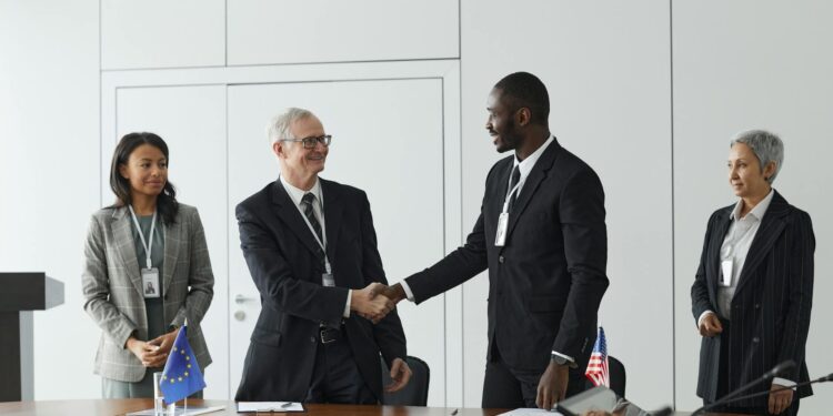Ripple representatives shake hands with Singapore Central Bank officials in a conference setting.