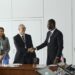 Ripple representatives shake hands with Singapore Central Bank officials in a conference setting.