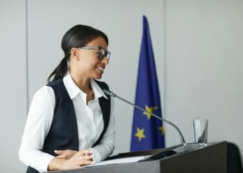 Kalshi co-founder speaking at a podium, addressing regulatory challenges in finance.