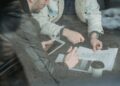 US lawmakers seated at a table reviewing documents on tokenized securities regulations.
