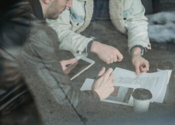 US lawmakers seated at a table reviewing documents on tokenized securities regulations.