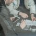 US lawmakers seated at a table reviewing documents on tokenized securities regulations.