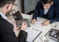 Business professionals discussing cryptocurrency strategy in a modern office setting.