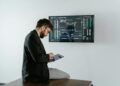 A financial analyst discusses cryptocurrency regulations with XRP graphics displayed on a screen.