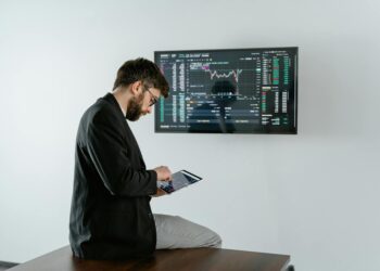A financial analyst discusses cryptocurrency regulations with XRP graphics displayed on a screen.