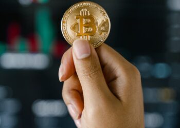 A lawyer holds a gavel with digital currency symbols in the background, representing finance and crypto.