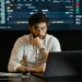 A developer analyzing blockchain data on a laptop with cryptocurrency graphics in the background.