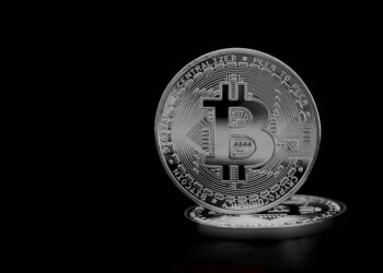 A digital representation of Bitcoin symbols with mining equipment and financial graphs.
