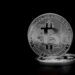 A digital representation of Bitcoin symbols with mining equipment and financial graphs.