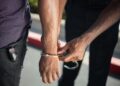 Law enforcement officers detain a suspect in a cryptocurrency-related kidnapping case.