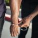 Law enforcement officers detain a suspect in a cryptocurrency-related kidnapping case.