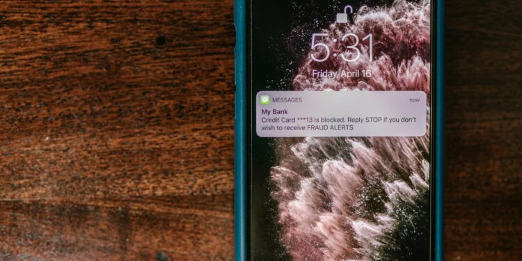 A smartphone displaying cryptocurrency icons with a warning alert on the screen.