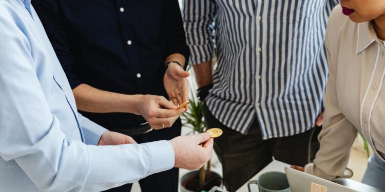 A diverse group of investors discusses cryptocurrency investment strategies in an office setting.