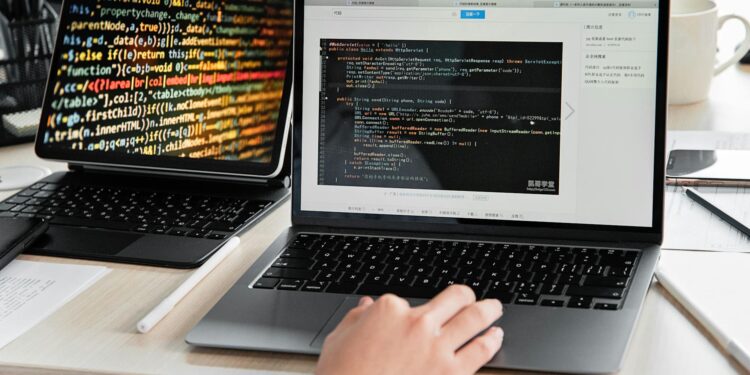 A developer works on a laptop displaying cryptocurrency exchange interface and code.