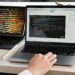 A developer works on a laptop displaying cryptocurrency exchange interface and code.